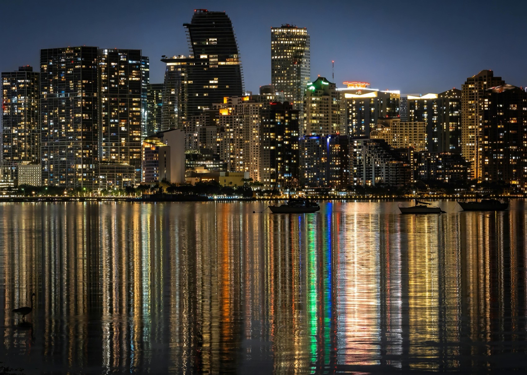 The Miami skyline at night, glittering and mirrored in Biscayne Bay