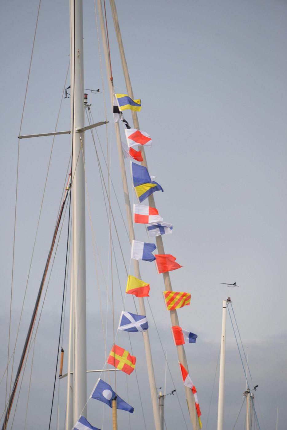 Nautical signal flags strung up a sailboat mast — the regatta dressing