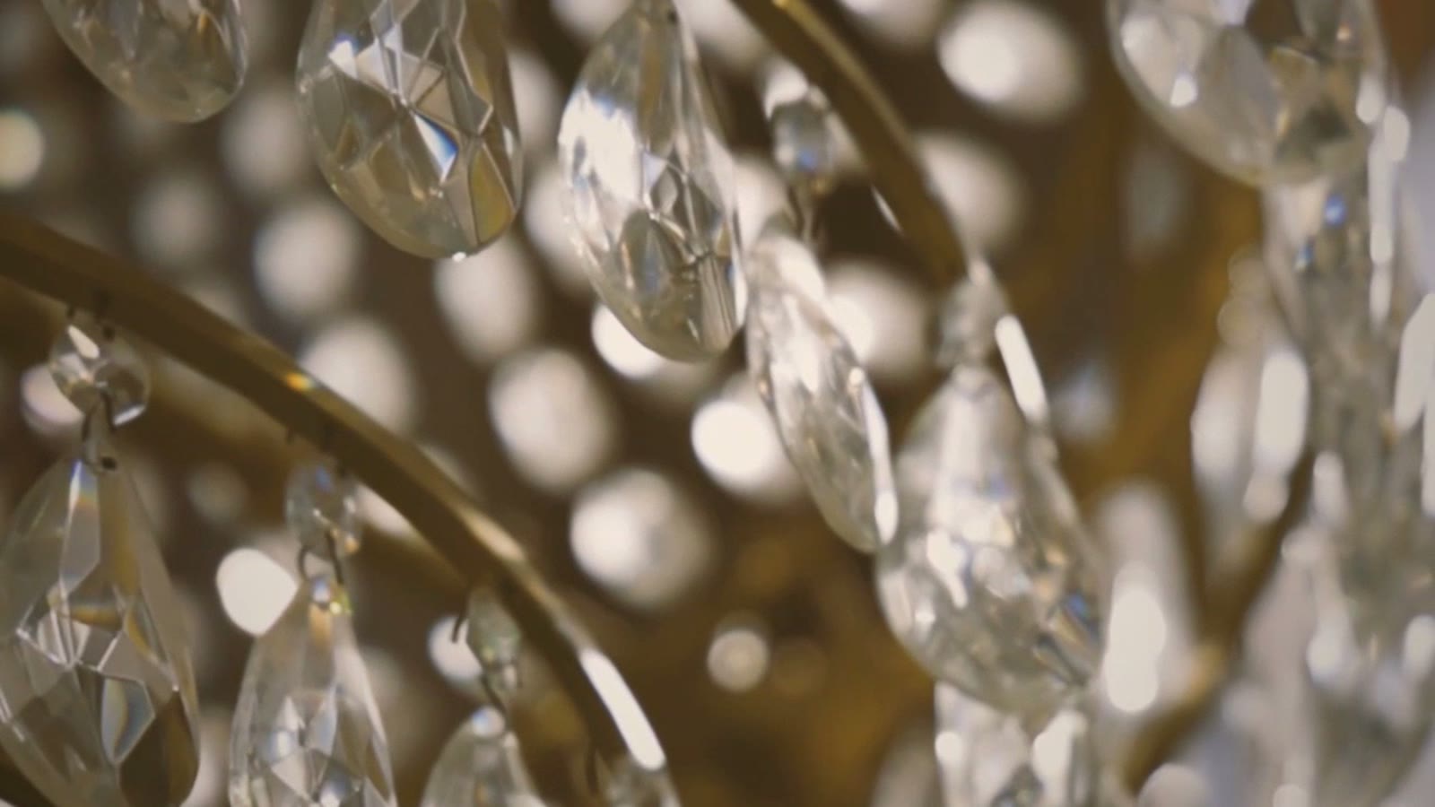 A crystal chandelier in close detail, candlelight bokeh beyond