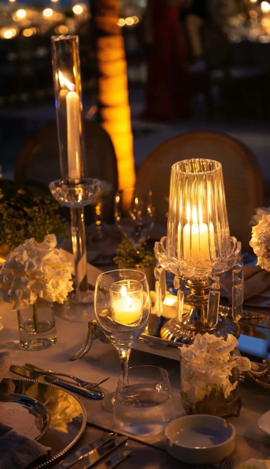 White taper candles and hydrangea on a candlelit banquet table